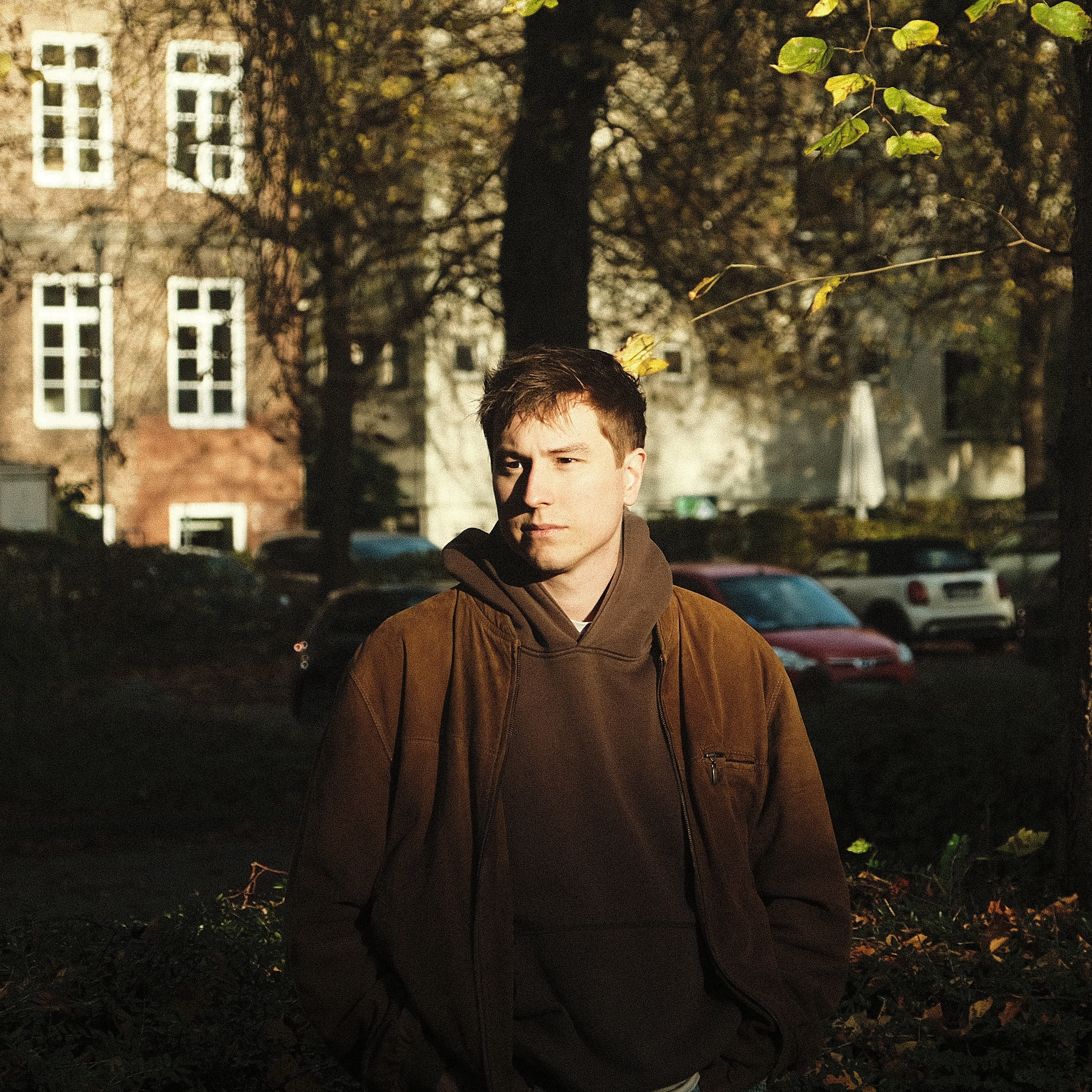 Professional studio portrait of an audio engineer working at a desk with headphones, moody lighting, dark background